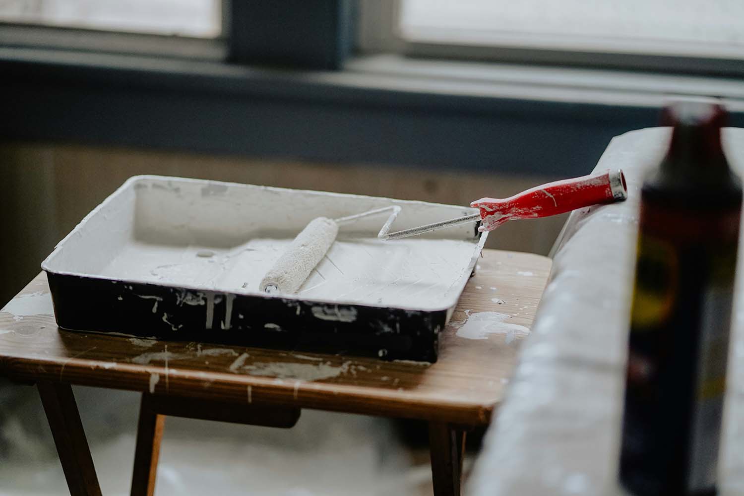 A paint roller loaded with white paint